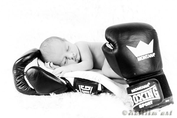 Photographie d'un bébé allongé sur un gant de boxe réalisée par Huitièm'art, photographe à Avignon (Vaucluse)