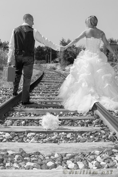 Photographie de mariés marchant le long d'un chemin de fer réalisée par Huitièm'art, photographe à Avignon (Vaucluse)