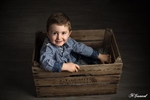 Photographie d'un petit garcon assis dans une caisse en bois en contre plongée réalisée par noelle gamand huitièm'art à avignon vaucluse