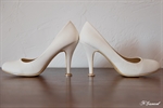 Photographie de chaussures d'une mariée avec les alliances sous les talons réalisée par noelle gamand photographe huitièm'art à avignon vaucluse