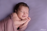 Photographie d'un nouveau né fille les yeux ouvert sur une couverture marron dans un body dentelle blanche réalisé par noelle gamand photographe nouveau né avignon vaucluse