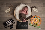 photographie d'un nouveau né garçon dans un  panier osier avec horloge metre ardoise date poid heure réalisée par noelle gamand photographe bébé avignon vaucluse